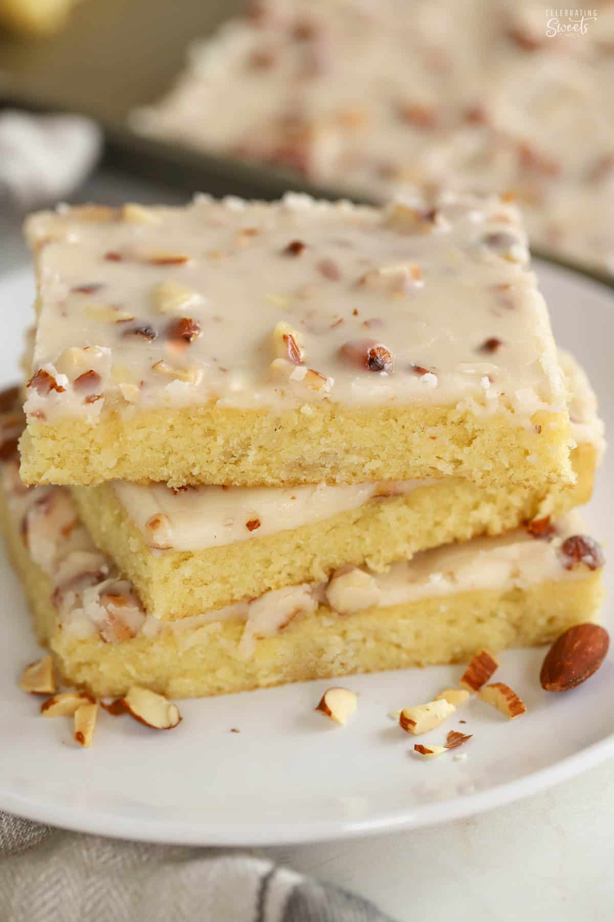 Stack of three slices of white Texas sheet cake on a white plate.