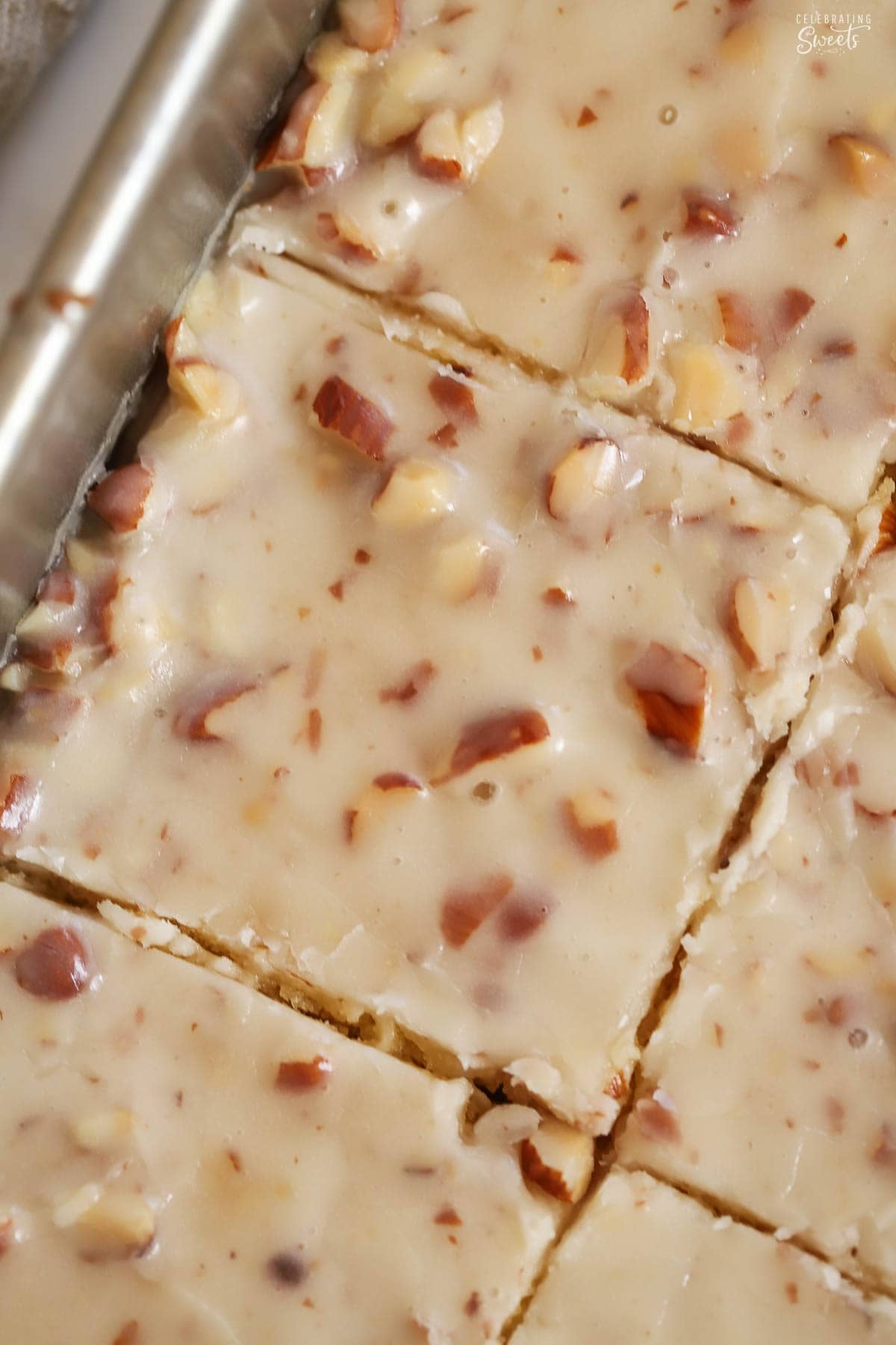 Overhead photo of the almond-studded icing on a white Texas sheet cake.