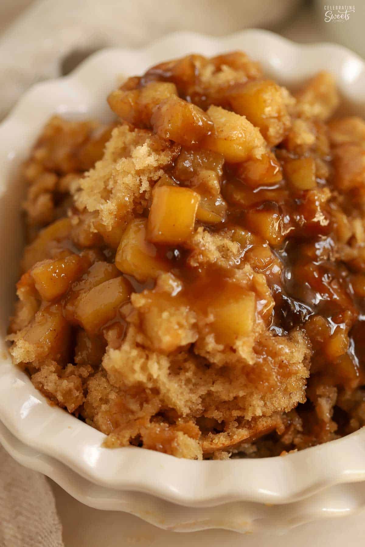 Caramel apple cake scooped into a white bowl.