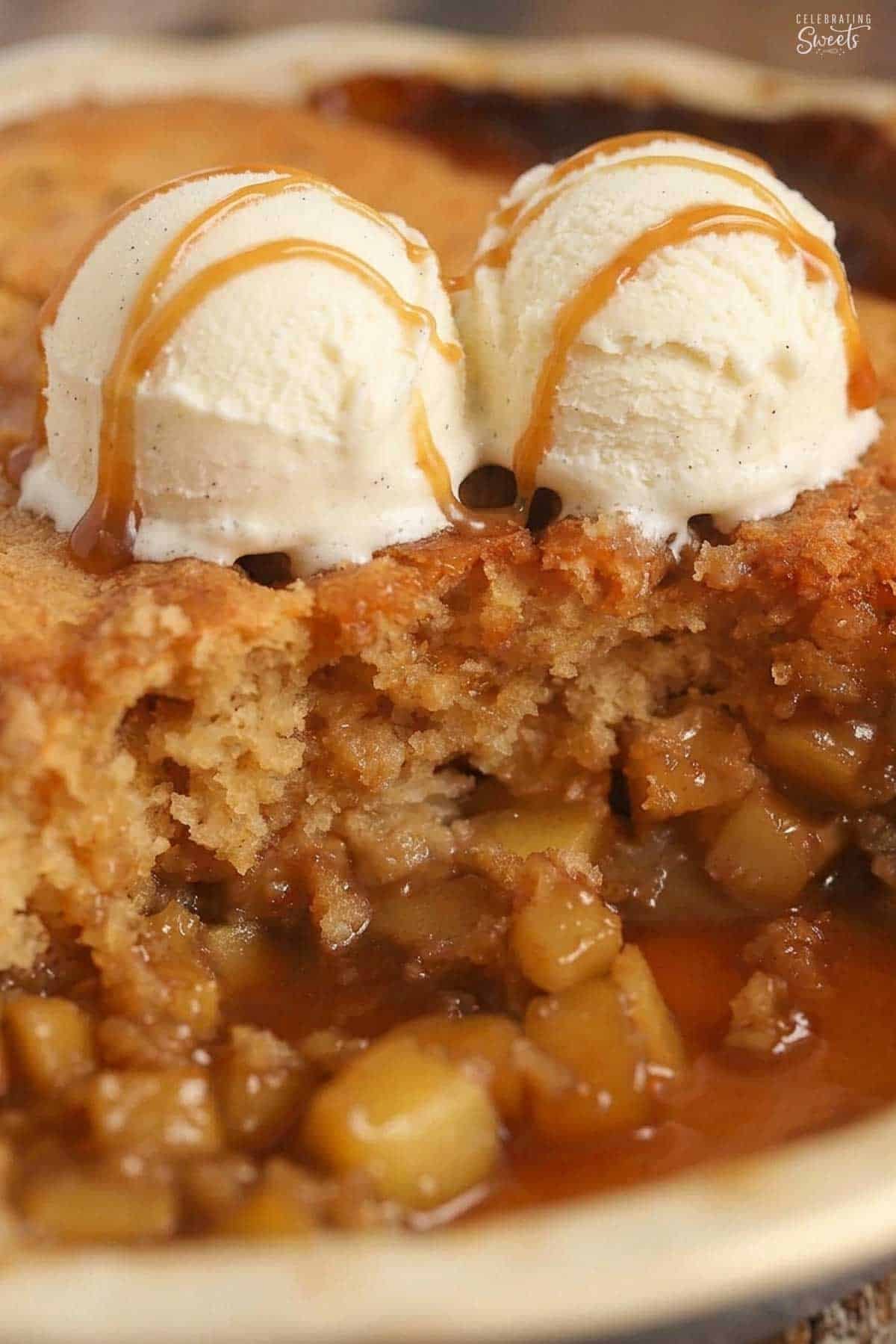 Cake on top of diced apples in caramel sauce topped with two scoops of ice cream.