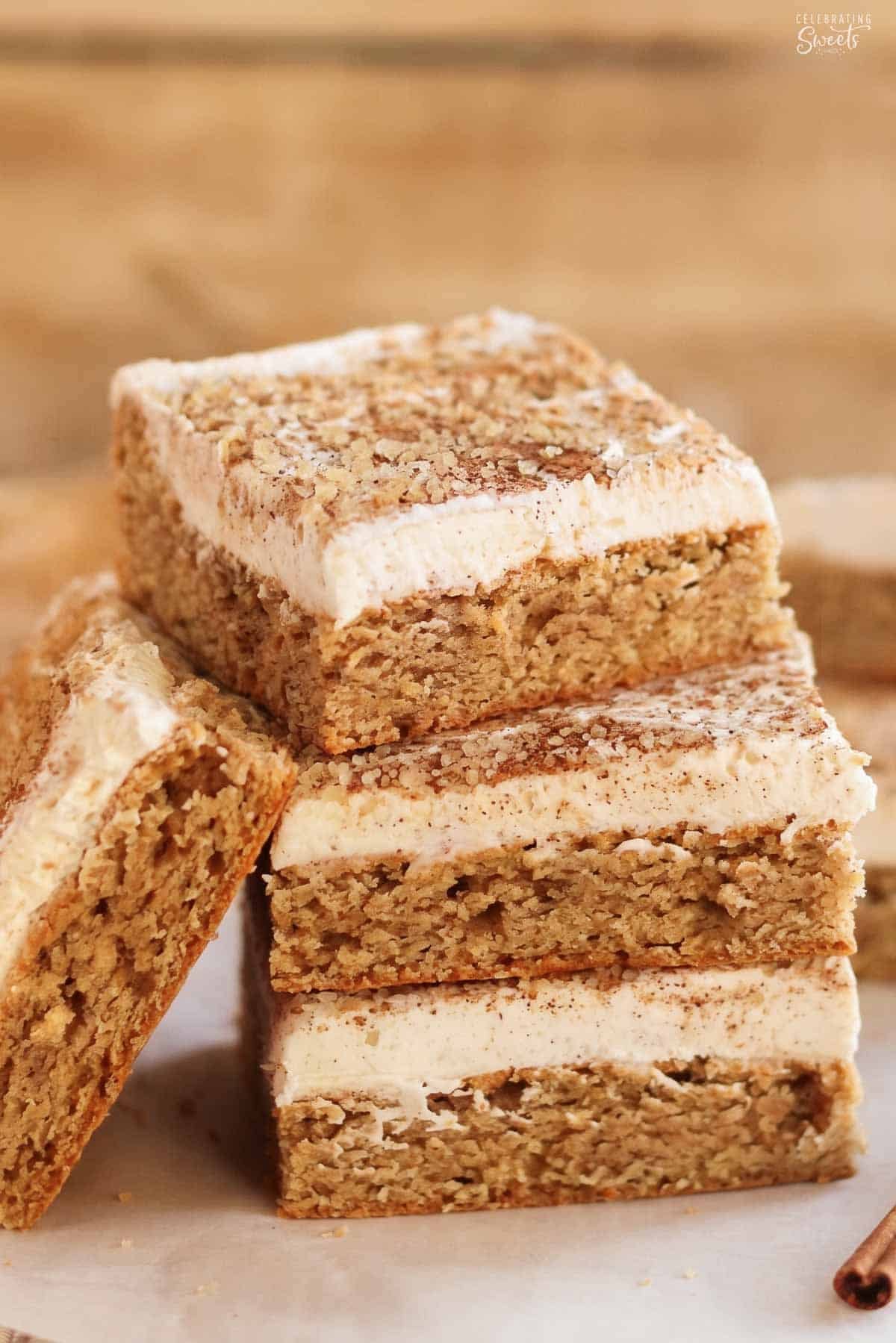 Stack of four frosted chai cookie bars on parchment paper.