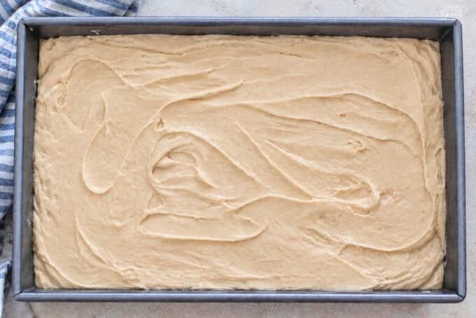 Maple buttermilk cake batter in a 9x13 metal pan.