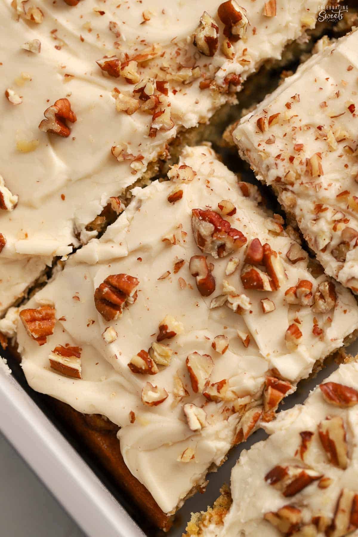 Overhead photo of slices of maple cake with maple frosting topped with pecans.