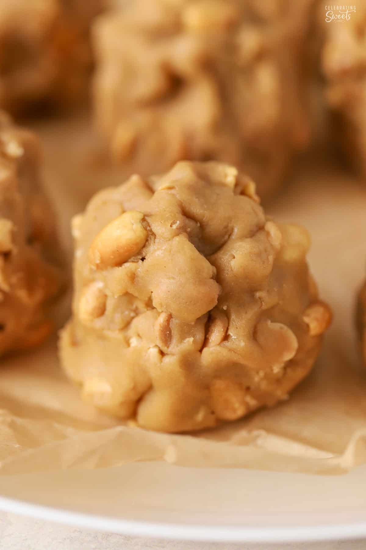 Unbaked peanut cookie dough ball on a parchment-lined plate.