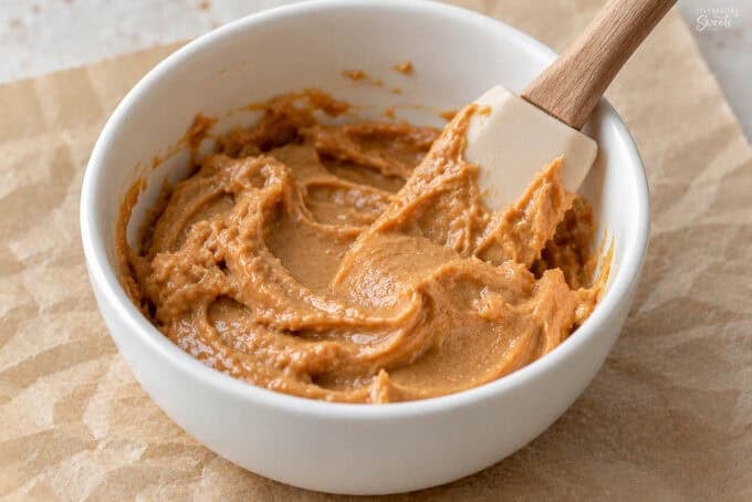 Peanut butter and honey in a white bowl.